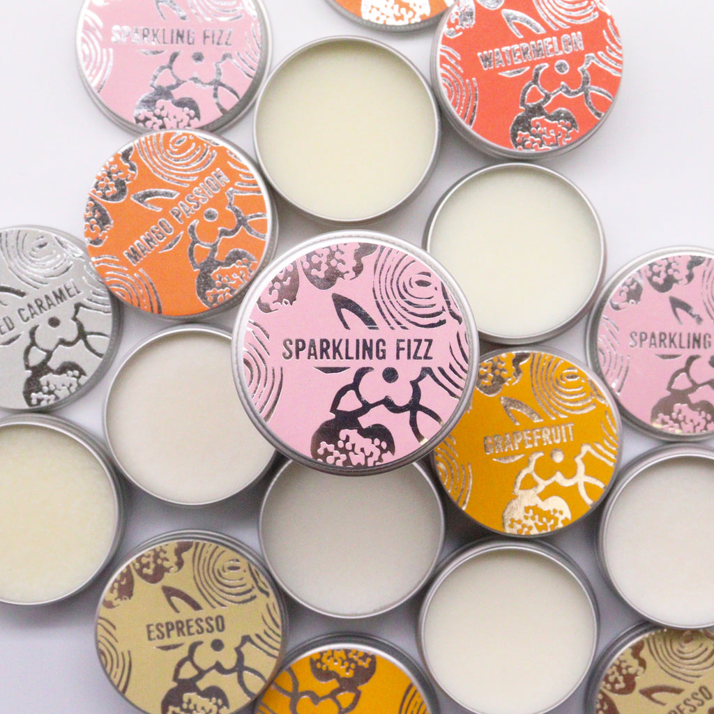 Collection of lip balm small tins. Sparkling fizz fragrance with plastic free packaging and vegan. image colorful labels on a white background.