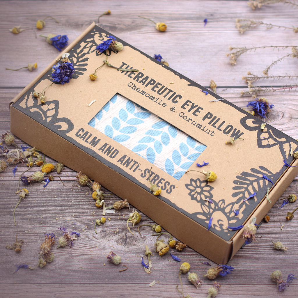 Therapeutic eye pillow. Calm and anti stress, chamomile and corn mint. Image with dried flowers on a wooden surface. vegan and cruelty/plastic free.