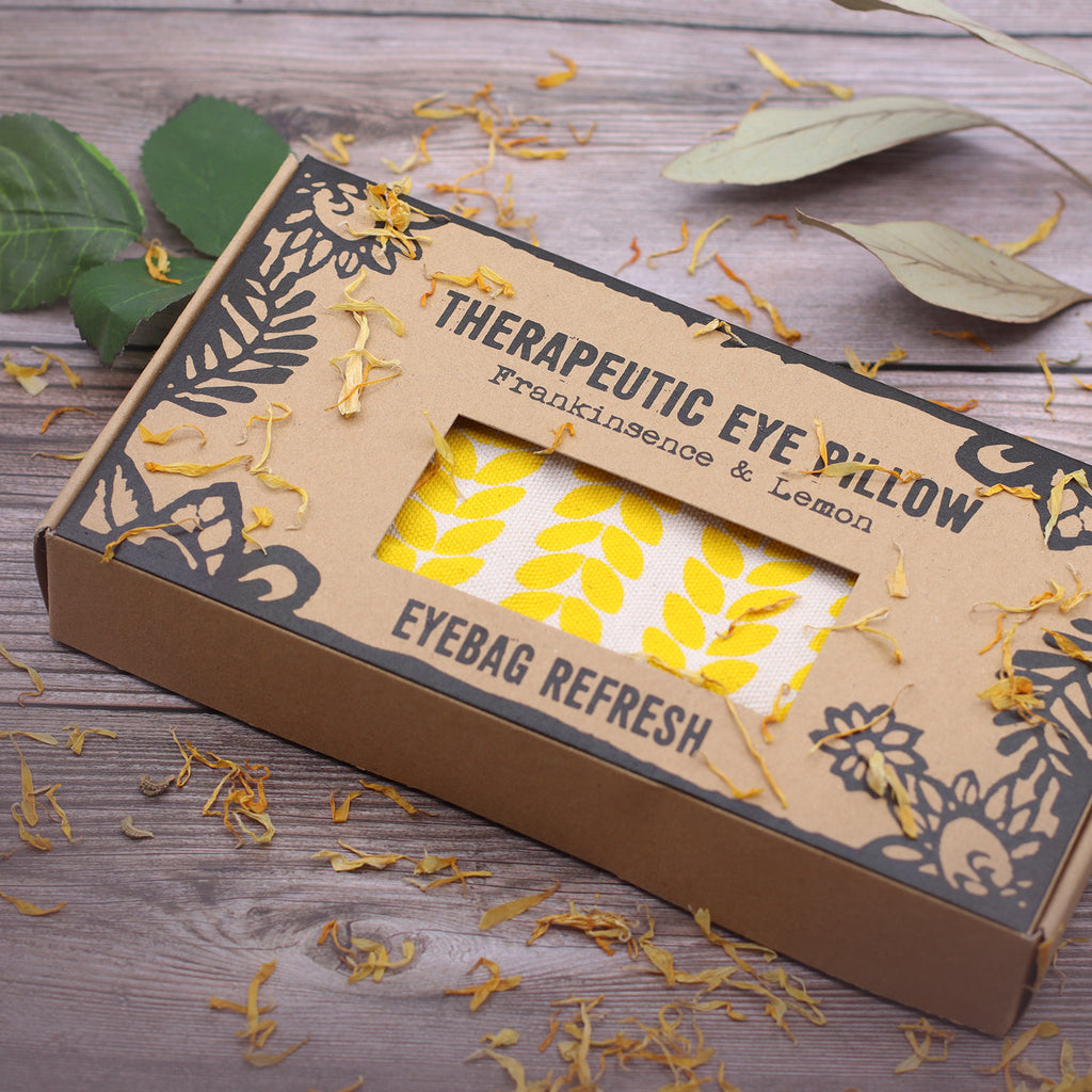 Therapeutic eye pillow frankincense and lemon. plastic free packaging. image shown with yellow leaves on a wooden surface. vegan